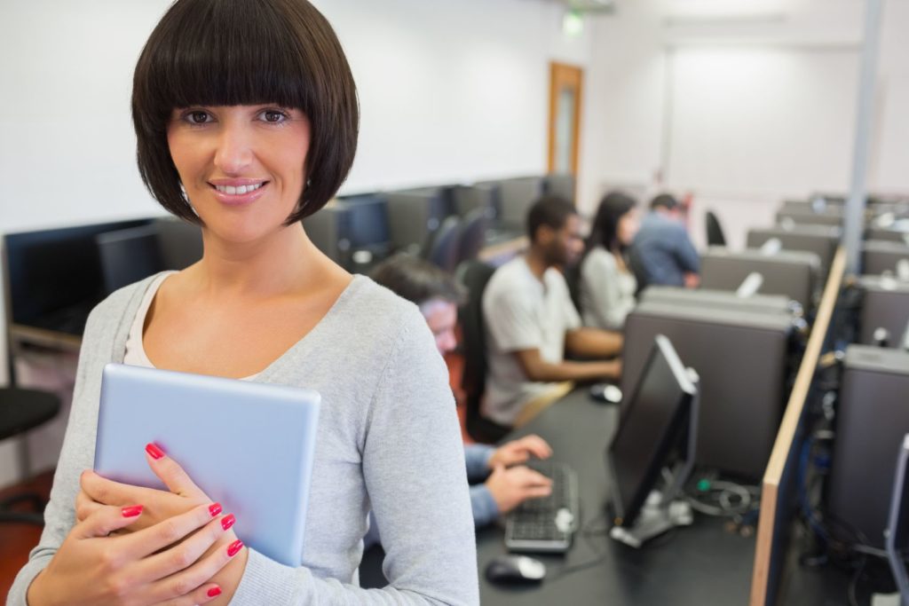 teacher with tablet pc in computer class