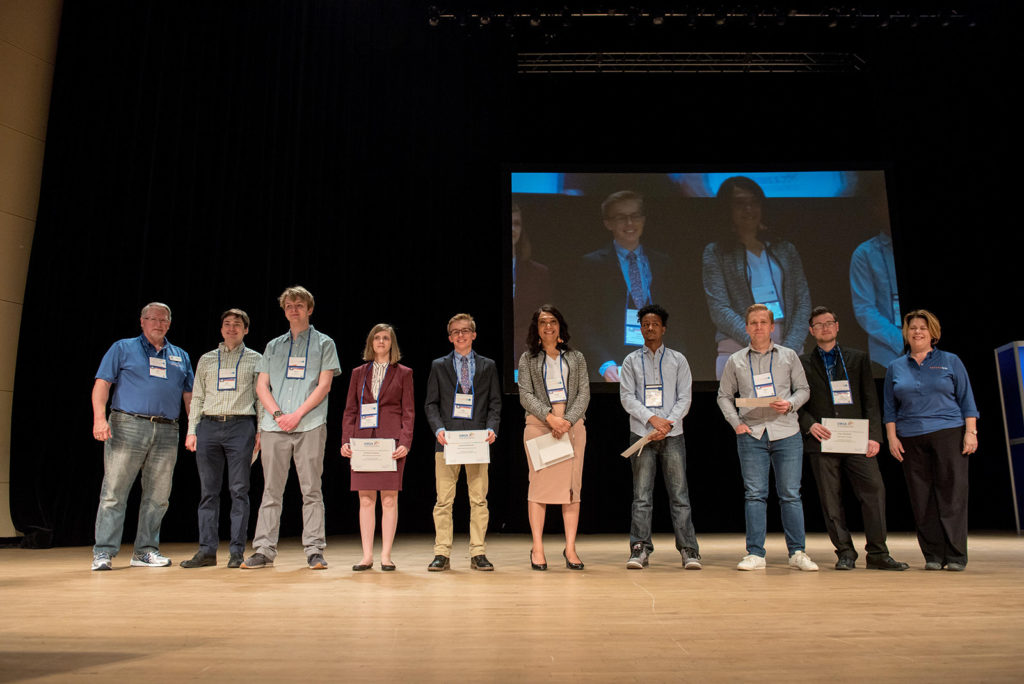Group of students standing on a stage receiving scholarship awards