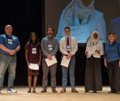 Group of students on a stage receiving scholarship awards