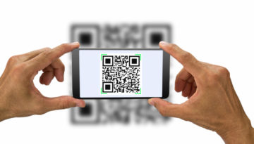 Hands holding smartphone scanning QR code on white background, business concept