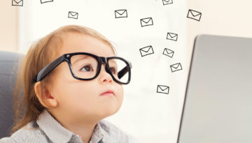 Email concept with toddler girl using her laptop